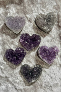 Heart-shaped purple crystals on a gray fabric surface